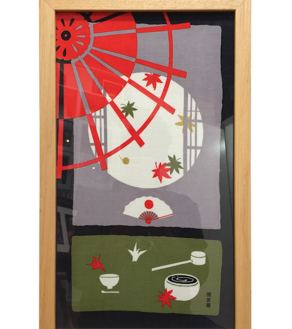 A Japanese material framed in a lacquered pine frame with glass.