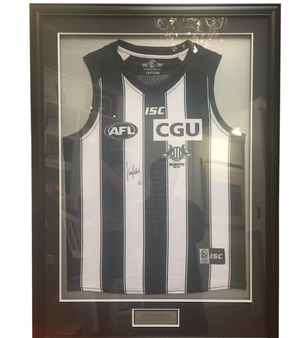 A Collingwood football club jersey signed by the captain Scott Pendlebury framed in a black frame with double mat board surround, UV glass and plaque.