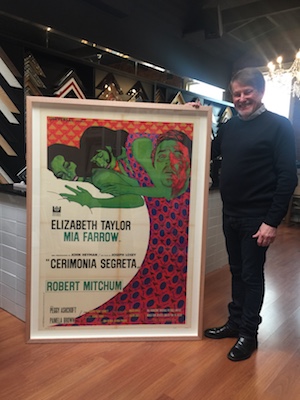 Our framer Greg Mahoney with an old movie poster framed in a Tasmanian oak box frame with the poster floated and raised from the mat board backing.