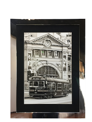A print of Flinders Street Station framed in a silver metallic frame with a mat board surround and non reflecting art glass.