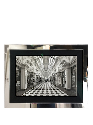 A black and white photograph of Royal Arcade Melbourne that has been framed in a silver metallic frame with a mat board surround and non reflecting art glass.