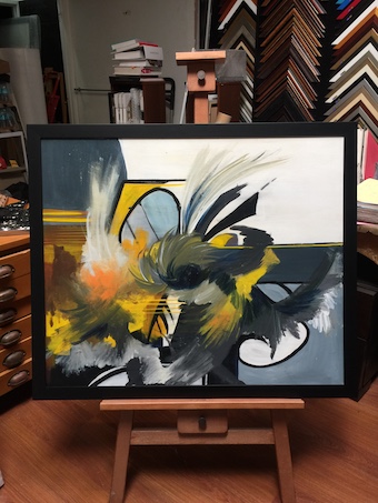 A large abstract painting stretched and framed to the edge in a black timber frame.