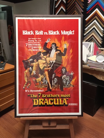 A large vintage Dracula movie poster framed in a black box frame with acrylic front.
