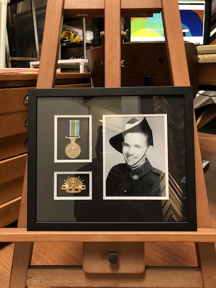An Army photograph and medals framed in a black frame with double mat board surround and UV glass.