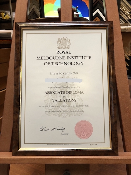 An RMIT certificate framed in a walnut and gold frame with non reflecting glass.