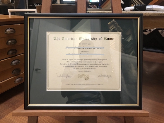 An American University of Rome certificate framed in a black and gold frame with mat board surround and UV glass.