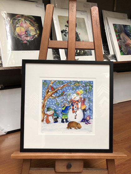 A fun snowman limited edition print framed in a black timber frame with a white mat board surround and UV glass.