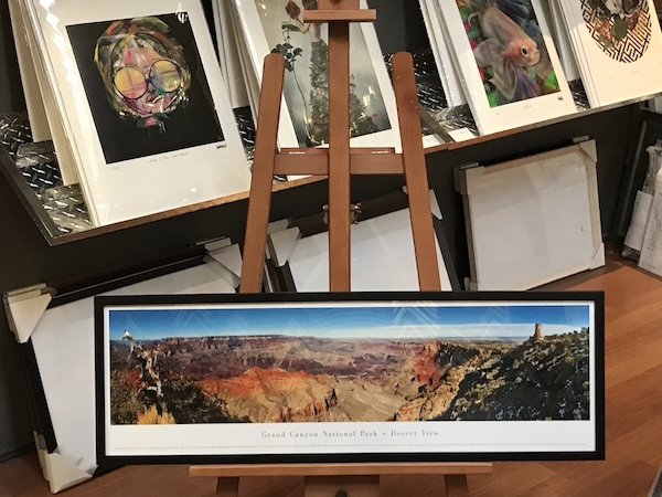 This is a large panaramic photographic print of the Grand Canyon framed in a square black timber frame with glass.