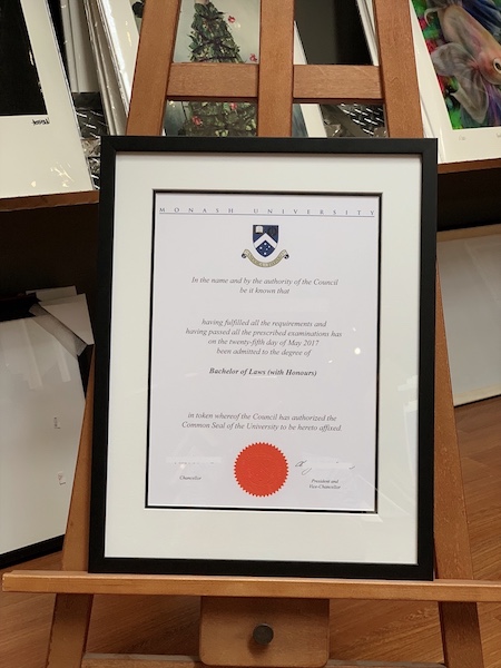 A Monash University Bachelor of Laws with Honours framed in a black timber frame with double mat board surround and UV glass