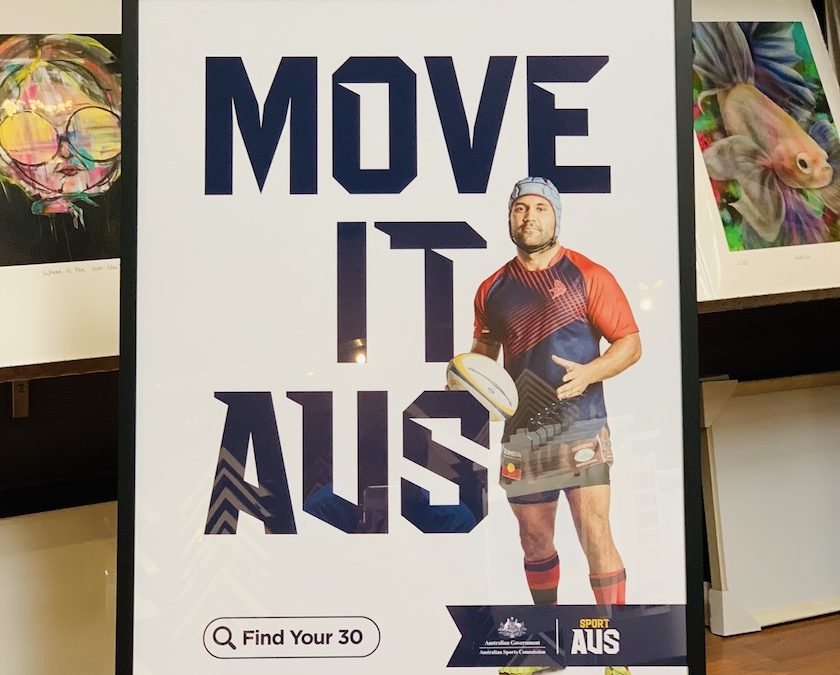 A rugby Sport Aus promotional print part of the Move It Aus campaign framed in a black box frame with glass.