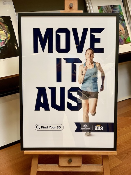 A running Sport Aus promotional print part of the Move It Aus campaign framed in a black box frame with glass.