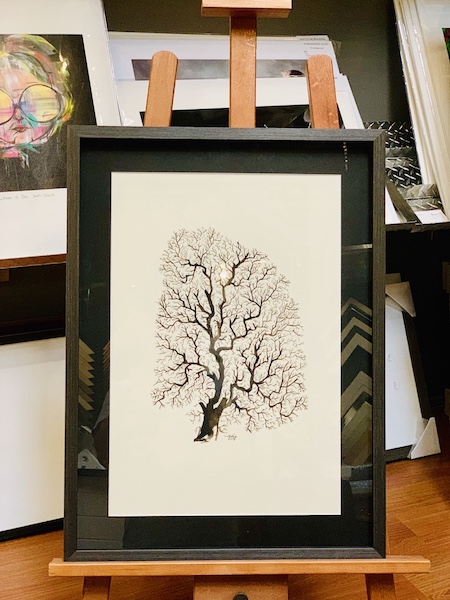 An original watercolour of a tree framed in a walnut box frame with a black mat board surround.