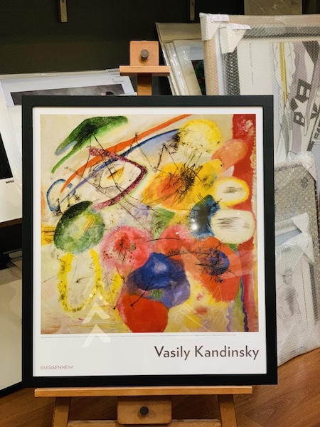 A Kandinsky poster framed in a black timber frame with glass.