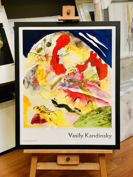 A Kandinsky poster from the Guggenheim museum framed in a black timber frame with glass.