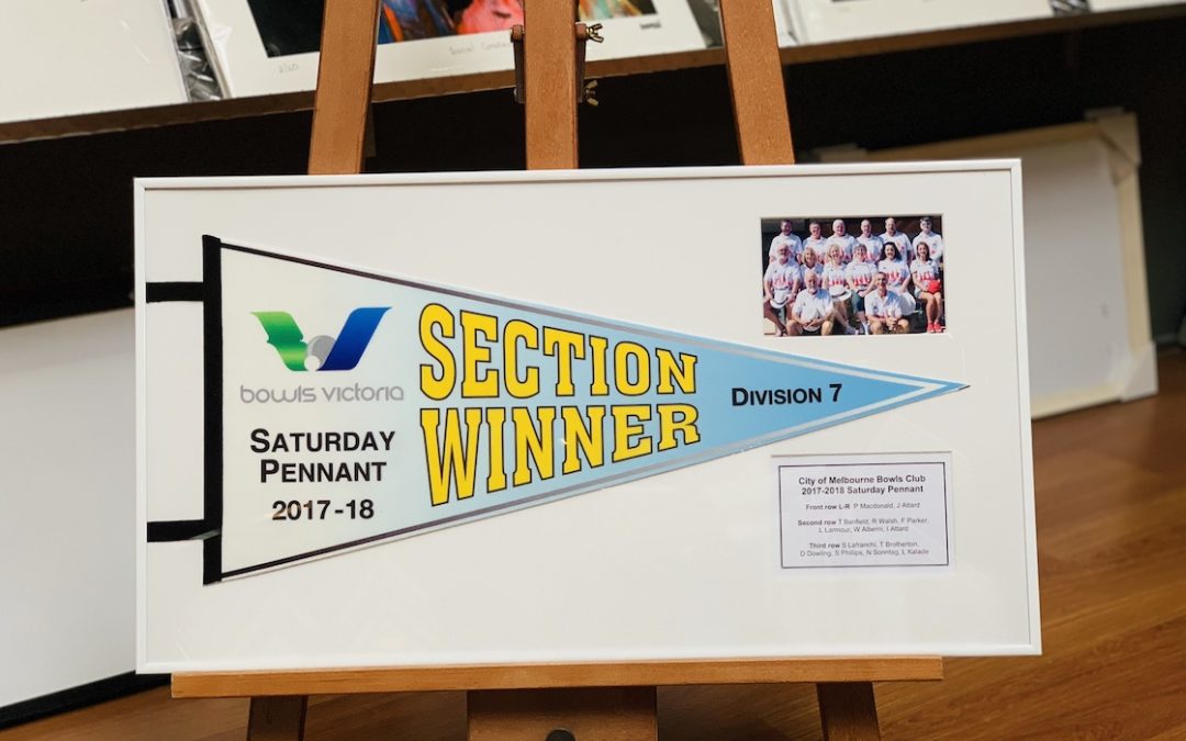 A Bowls Victoria club pennant framed in a white aluminium frame with multiple openings and mat board surround.