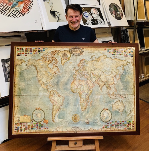 Greg Mahoney with an extra large jigsaw puzzle framed in a walnut frame with perspex.