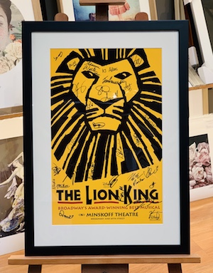 A collectable poster of the musical The Lion King that has been signed by the cast. The frame is black, the mat board surround is white and we have used UV glass to prevent the poster and signatures from fading