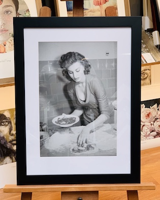A classical black and white photo framed in a black frame, white mat and glass
