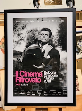 An old Italian movie poster framed in a black frame, white mat and glass