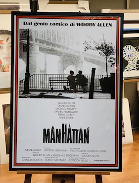 An Italian poster for the movie Manhattan framed in a black box frame and glass