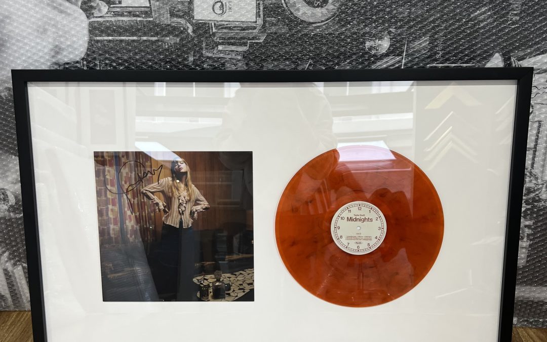 This happy client asked us to frame Taylor Swift’s newest album, Midnights, in a black contemporary custom frame. The signed photograph and vinyl record album were mounted on a 3mm foam core that creates a floating effect, and we used UV glass to protect it from fading.